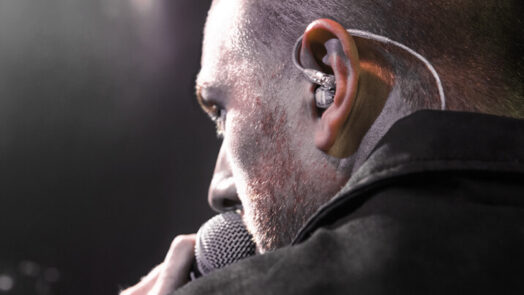 vocalist using Shure in-ear monitors on stage